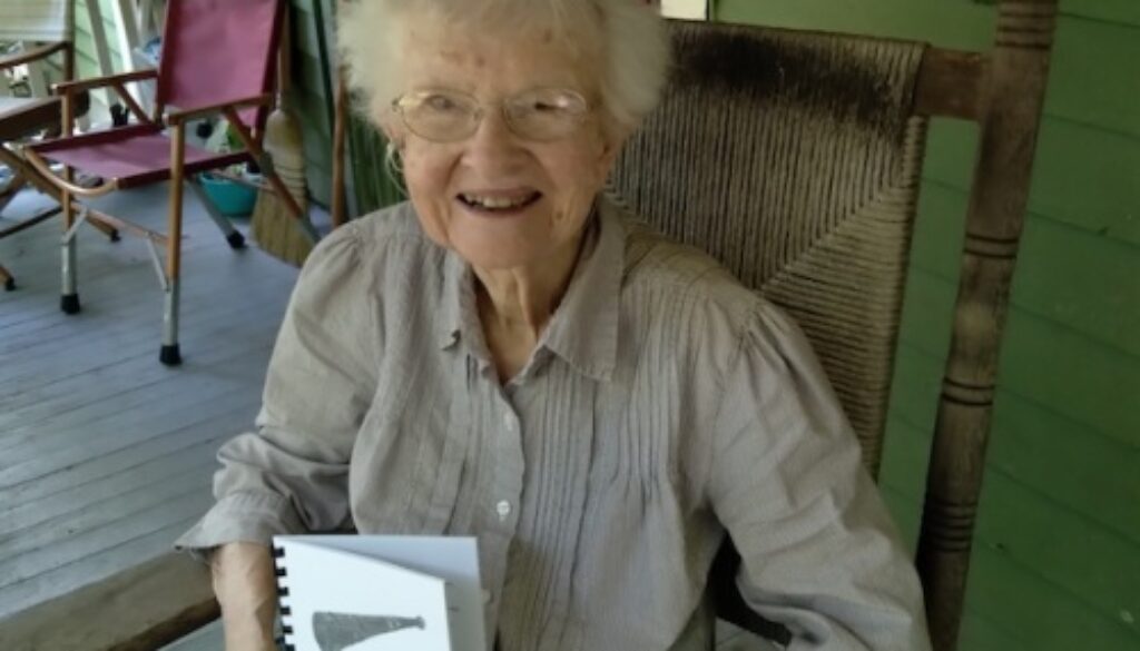 Beth Holtam in a rocking chair with book.