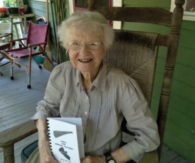 Beth Holtam in a rocking chair with book.