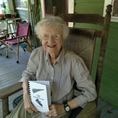 Beth Holtam in a rocking chair with book.